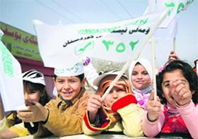 Iraqi children wave banners of the Kurdish Islamic bloc in Arbil on Friday. Official campaigning begins on Saturday for the country's March 7 general election, only the second since now-executed dictator Saddam Hussein was ousted in the US-led invasion of 2003.