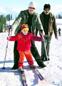 A tourist teaches his child how to ski at the skiing resort at Gulmarg on Saturday