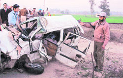 The mangled remains of the car that collided with a train at an unmanned level crossing near Patiala on Saturday.