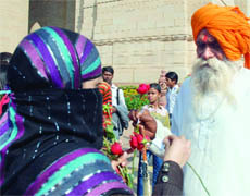  A girl from Real Cause, an NGO, presents a rose to an  old man on Valentines Day at the India Gate in New Delhi on Sunday.