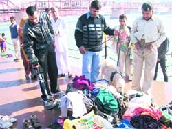 Securitymen check the belongings of a pilgrim in Haridwar on Sunday. 