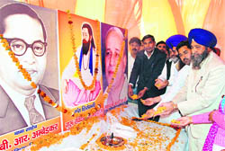 BSP general secretary Mansingh Manhera pays floral tributes to Dr BR Ambedkar, Guru Ravidass and Kanshi Ram at a function at Sadar Bazar in Karnal on Sunday.