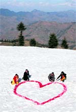 Tourists paint a red heart on snow to mark Valentines Day at Kufri, 23 km from Shimla, on Sunday