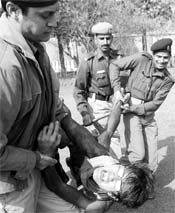 Police personnel take away a Tibetan protester outside the Chinese Embassy in New Delhi on Sunday