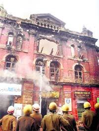 Fire personnels try to douse the fire that started at a warehouse at Strand Road near Burrabazar area in Kolkata on Sunday