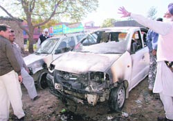 People have a look at the cars set afire by miscreants in Mani Majra on Monday.