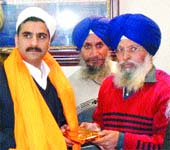 SGPC Information Officer Gurbachan Singh presents Amritsar Police Commissioner Varinder Kumar a Siropa in the Golden Temple premises.