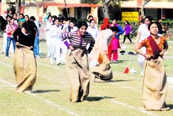 Students particiapte in a sack race in Ludhiana on Monday