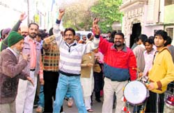 Safai karamcharis dance to the tunes of dhol after the MC passed their demand of regularisation during the budget on Monday