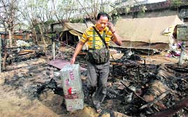 A policeman carries his colleagues belongings at a camp that was attacked by Maoists at Silda village, 200 km west of Kolkata.