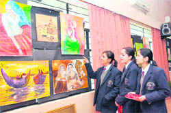 Students have a look at paintings at an exhibition at St Josephs Academy School in Dehradun