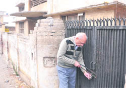 Surinder Jathaul cuts the lock that was put up by a land grabber on the main gate of his house in Ludhiana.