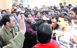 Students talk to police officials after a quarrel between two factions at DAV PG College in Dehradun