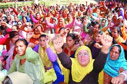 Aanganwari workers protest outside the Deputy Commissioners office in Amritsar on Friday.