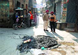 Garbage and filth left in the middle of the road after desilting the sewerage in the Sharifpura locality in Ward 27 in Amritsar.