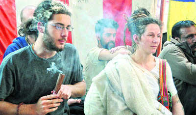 Two foreigners attend a ritual during the Maha Kumbh in Haridwar.