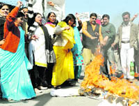 Mahila Congress workers burn an effigy of the state government in Dehradun on Friday.