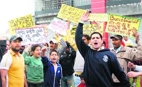 Labourers and local residents raise slogans against the owner of an underconstruction shopping complex in Jammu on Friday.