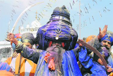 Their dark blue dresses, coupled with peaked turbans, often surmounted with steel rings, daggers and plumes affixed, give them a peculiar expression of energy.