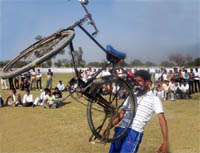 A student lifts a bicycle with his teeth during the annual sports meet of the MR Government College in Fazilka