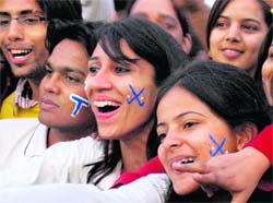Spectators cheer players during the exhibition match at the Sector 42 Hockey Stadium in Chandigarh on Saturday.