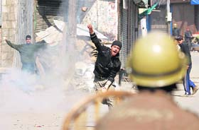 A youth throws a stone at a policeman in Srinagar