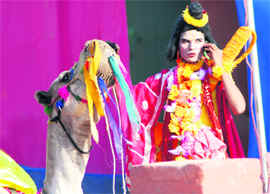 Listening to God: Modern-day Naradmuni talks to the God over a mobile while resting his hand on a camel during the Rajasthani Art & Craft Festival at Kalagram in Chandigarh.
