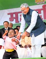 Bihar CM Nitish Kumar with a Dalit activist at a rally in Gandhi Maidan in Patna on Sunday.