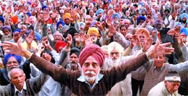 Members of the Punjab Government pensioners joint front block road in front of the District Administrative Complex in Jalandhar on Monday.