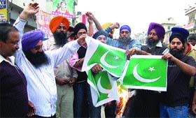 Demonstrators burn Pakistani flags in Jalandhar on Monday in protest against beheading of two Sikhs by the Taliban.