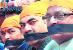 Former MP Satya Pal Jain (extreme right) with UT BJP president Sanjay Tandon (centre) sit on a peace protest against the killing of Sikhs in Pakistan, in front of the Sector 46 gurdwara, Chandigarh, on Tuesday.