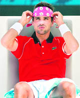 Arnaud Clement adjusts his headband during his first round match against Marion Cilic in Dubai