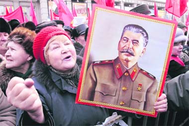 A Russian communist supporter holds a portrait of Soviet dictator Josef Stalin during a protest in central Moscow on Tuesday. Communists gathered to protest against the government's policy on Defender of the Fatherland Day, originally known as Red Army Day, to honour the soldiers of the Russia's military. 