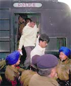 Policemen shift prisoners to another vehicle