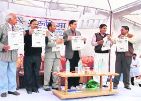 Deputy commissioner OP Sheoran (centre) releases the inaugural issue of rural newspaper Arunima at Mugalpura village, near Hisar