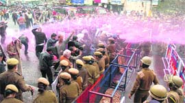 Policemen use water canons to disperse agitating employees near the Civil Secretariat in Jammu on Thursday.