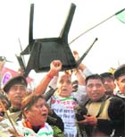 BJP leader Rajnath Singh lifts a chair during a clash with the police in Lucknow on Thursday.
