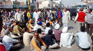 Truck operators staging a dharna and blocking traffic on the Bathinda-Goniana road near the Hanuman Chowk on Friday.