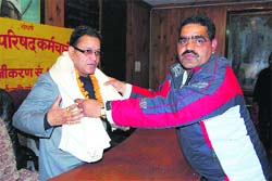 A palika employee felicitates its president OP Uniyal in Mussoorie on Friday.