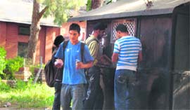 Students queue up in front of a tiny tea stall.