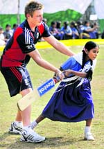 A Bangladeshi schoolgirl receives some batting tips from England cricketer Luke Wright during a game at The Sher-e-Bangla Government Primary School in Dhaka on friday