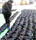 A man searches for his shoes among recovered shoes stolen by a shoe thief at a police station in Seoul on Friday. The police arrested the 59-old-year thief, identified as Park, who has stolen about 1,200 pairs of luxury-brand shoes at funeral halls of large hospitals and stored them at his warehouse to sell on a street