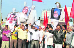 Activists of the Hindu-Sikh Jagriti Sena burn effigies of Manmohan Singh, Rahul Gandhi and Pranab Mukherji, at the Jagraon bridge in Ludhiana