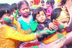 hildren of Daddy's Teddy, franchise of Kids Zee play school, apply colours on the face of a child dressed as Lord Krishna to mark Holi celebrations in Bathinda