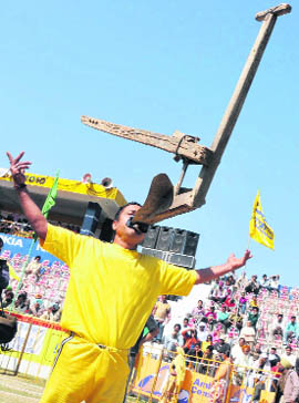 A man lifts a plough with his teeth