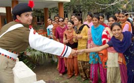 A student shakes hand with Mahila Praharis of the BSF