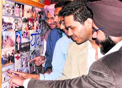 Old students of GNI Senior Secondary Public School look at photographs of their school days in Ludhiana on Sunday