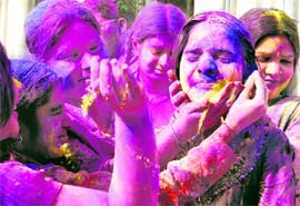Girls apply gulaal on the eve of Holi in Amritsar on Sunday