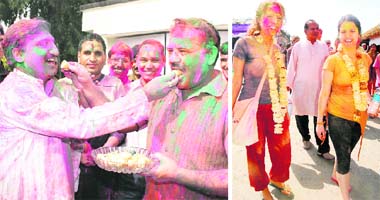 Uttarakhand Chief Minister Ramesh Pokhriyal Nishank offers sweets to Leader of Opposition Harak Singh Rawat on Holi in Dehradun; and (right) two foreigners bathed in Holi colours in Haridwar