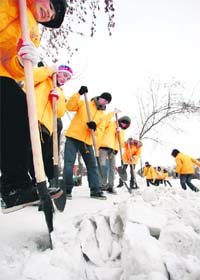 Teenagers remove snow at a park in the Siberian city of Krasnoyarsk